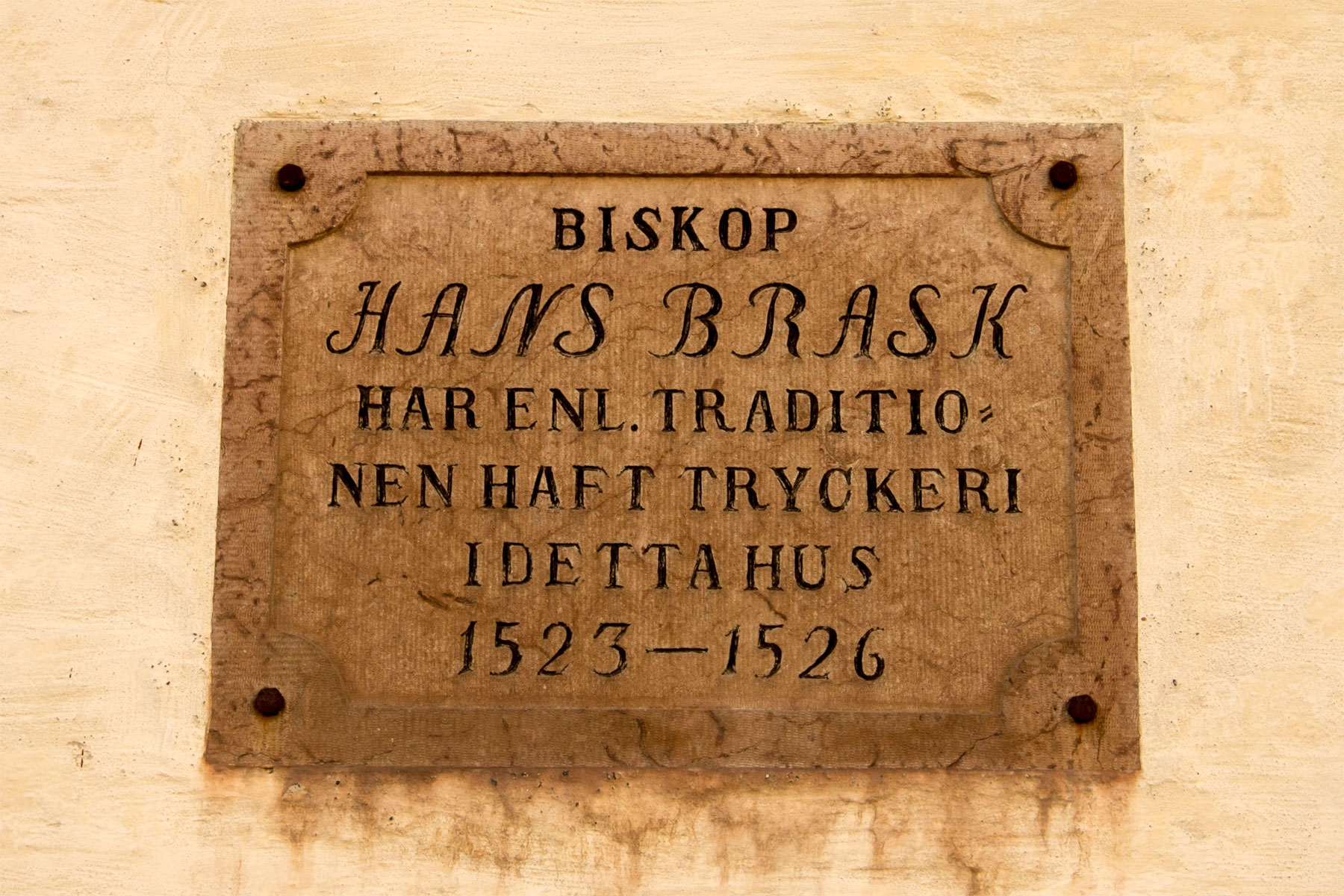 Minnesskylt över tryckeriet som biskopen kan ha drivit här.